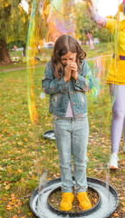 Cute little girl enjoys the bubble show at the birthday party.