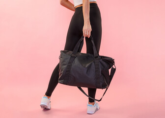 woman is holding a large sports bag on a monochrome background