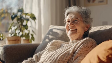 Happy senior woman smiling while relaxing. sitting on sofa at home looking at camera. Advertisement concept