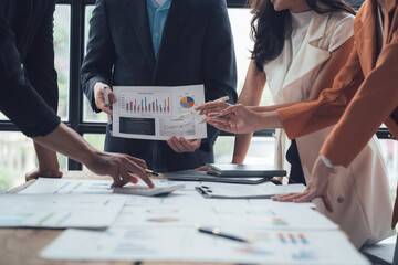 Strategic Business Meeting: Diverse team analyzing data charts and graphs during a collaborative meeting.  Focus on teamwork, planning, and financial success.