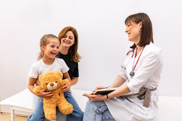 Happy laughing mom and her child, little daughter by doctor appointment in pediatrician office,...