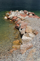 Old Rocky Jetty on Calm Clear Waters of Inland Italian Lake