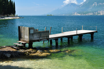 View of Lake Garda with Deserted Jetty and Beach on Sunny Day 