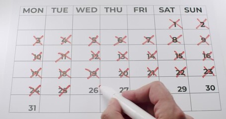 A time lapse video of a person using a red marker pen to cross off dates on a calendar. Useful for concepts such as time, deadlines, and appointments. Marking Dates On Calendar