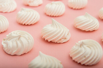 Delicious meringue cookies on light pink background, closeup. 