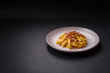 Crispy French fries with pieces of bacon, salt and spices