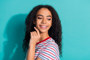 Photo portrait of pretty young girl look interested empty space wear trendy striped outfit isolated on cyan color background