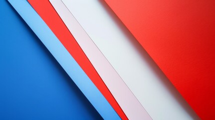 Multiple colored paper sheets overlap each other, creating a simple yet striking abstract composition of vibrant reds, blues, and whites.