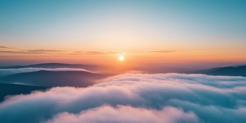 Obraz premium A breathtaking sunrise gently lights up the landscape, with misty hills and a sea of clouds stretching into the horizon.