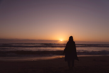 Mujer viendo el atardecer en el mar