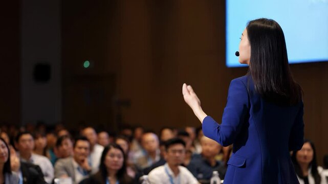 Business speaker in front of the audience or lecturer speaking in front of a hall of people, the concept of public speaking abstract fictional.
