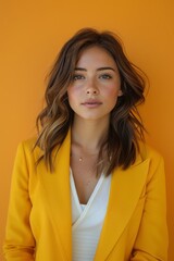 Obraz premium An approachable portrait of a female marketing executive in a bright yellow blazer and white top, vibrant orange background, vertical 