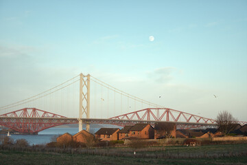 Two bridges through Fife at sunset. Forth Bridges crossing between Fife and Edinburgh at sunset, Scotland, United Kingdom