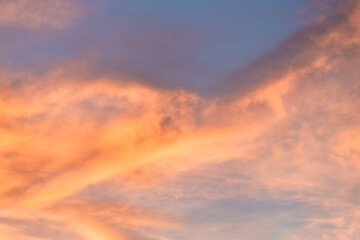 A beautiful sky tinted by the sun leaving vibrant shades of gold, pink, blue and multicolored. Clouds in the twilight evening and morning sky. Cloudy sky background in the evening, and during the day.