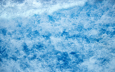 Struktur von sprudelndem Wasser hinter einer Glasscheibe