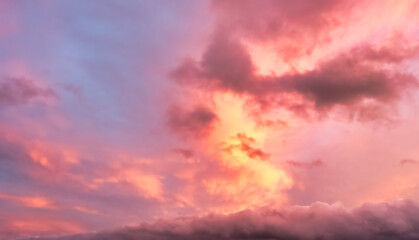 A beautiful sky tinted by the sun leaving vibrant shades of gold, pink, blue and multicolored. Clouds in the twilight evening and morning sky. Cloudy sky background in the evening, and during the day.