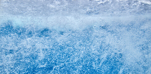 Struktur von sprudelndem Wasser hinter einer Glasscheibe