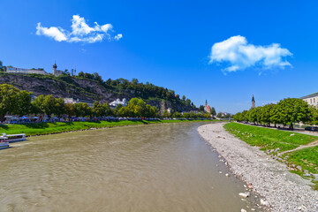 Clouds over the river shows the various spires of museums, clock towers, Salzburg, Austria