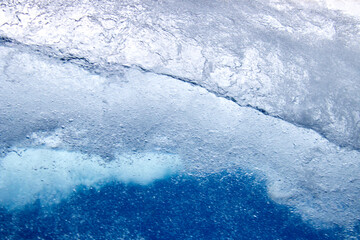 Struktur von sprudelndem Wasser hinter einer Glasscheibe