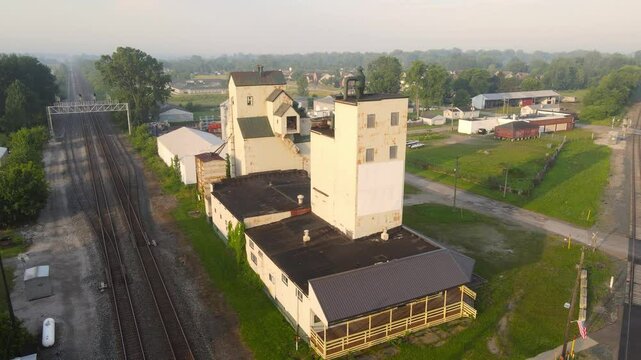 Close-up aerial view of grain silos near railroad tracks in small town, Carleton, Michigan, USA