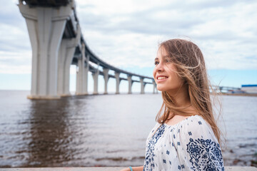 Rear view of a young girl looks on western high-speed diameter from Kanonersky Island in St....