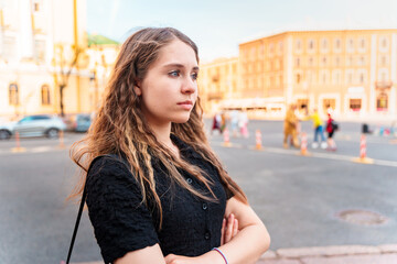 A pretty girl walks through the summer of St. Petersburg and stopped on the embankment, along the channels of which excursion boats go. Russian tourism