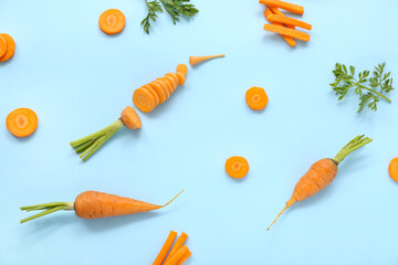 Fresh carrots and slices on blue background