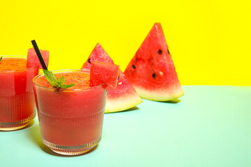 Glasses of tasty watermelon juice with mint on colorful background