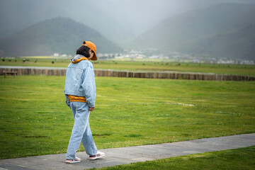 People with landscape,young girl in the denim jacket and trousers traveling and relaxing in beautiful nature. Feeling free and getting away from it all concept.