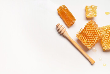 Sweet honeycombs and dipper on grey background