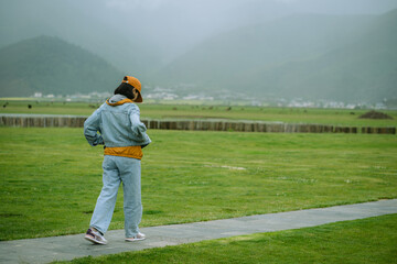 People with landscape,young girl in the denim jacket and trousers traveling and relaxing in beautiful nature. Feeling free and getting away from it all concept.