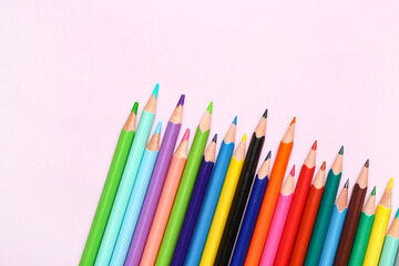 Group of colorful pencils on light pink background