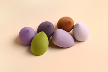 Different makeup sponges on beige background