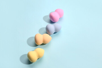 Different makeup sponges on blue background