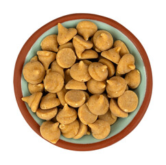 Overhead view of a small bowl filled with peanut butter baking chips isolated on a white background.