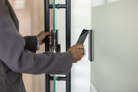 Business professional using smartphone for secure access to modern office building