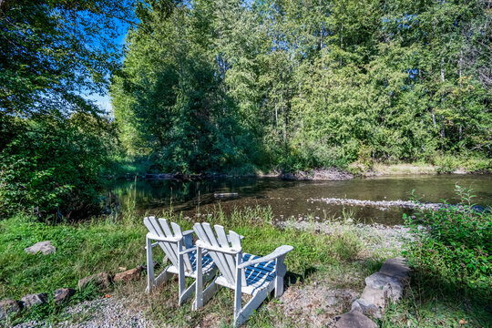 Two white chairs on the rivers edge