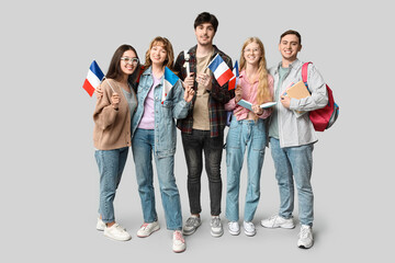Fototapeta premium Group of students with French flags on grey background