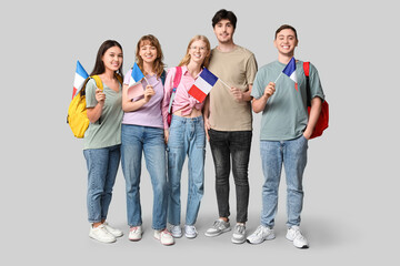 Obraz premium Group of students with French flags on grey background