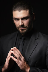 Strict male portrait. The guy in the classic black suit.