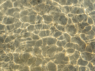 Reflections of light on the bottom of sandy shallows.