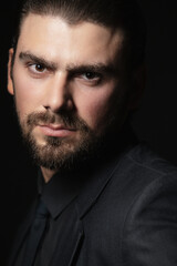 Strict male portrait. The guy in the classic black suit.