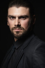 Fototapeta premium Strict male portrait. The guy in the classic black suit.