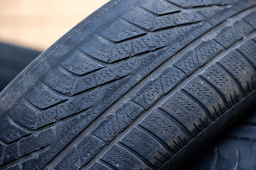 Worn and damaged tread of old tires lying in a landfill. Decreased road safety and environmental pollution from rubber waste © Fotoforce