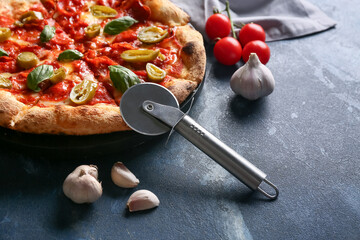 Composition with tasty pizza, ingredients and cutter on blue background, closeup