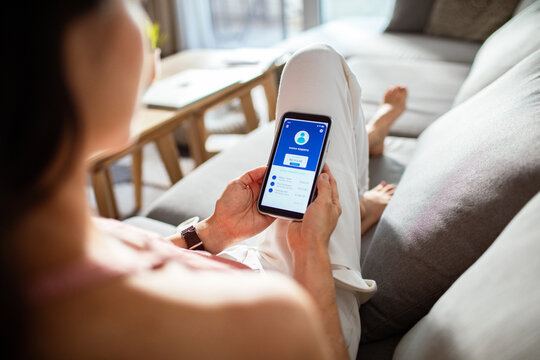 Woman checking financial app on smartphone at home