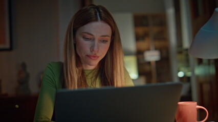 Exhausted woman closing laptop tired of remote work at night home close up.