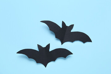 Black paper bats for Halloween party on blue background