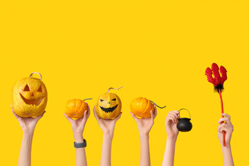Female hands with pumpkins, pitchfork and pot on yellow background. Halloween celebration