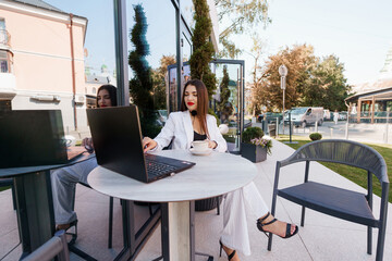 Professional Business Woman Engaged in Work Over Coffee in a Chic Outdoor Setting